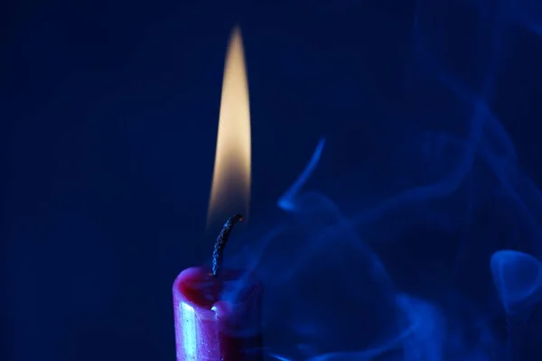 Una Vela Encendida Sobre Fondo Azul —  Fotos de Stock