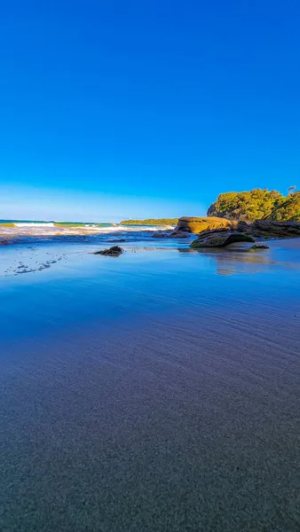 蔚蓝的天空下 波涛汹涌的大海拍打着岩石的海滩 美丽的景色 — 图库照片