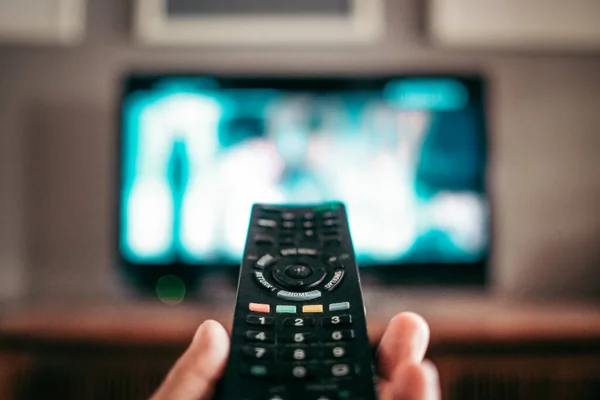 A closeup shot of a remote controller for a modern TV in a hand