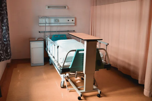 一张现代医院病床和靠近诊所窗帘的木制书桌的照片 — 图库照片