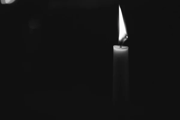 暗い背景に隔離された燃えるろうそくのグレースケール — ストック写真