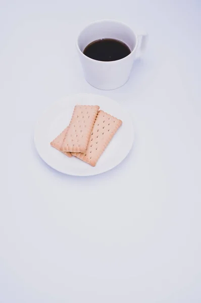 黒コーヒーをマグカップとプレートにビスケットの入った白い背景にコピースペース — ストック写真