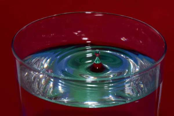 Primer Plano Vaso Agua Con Una Gotita Salpicante Sobre Fondo — Foto de Stock