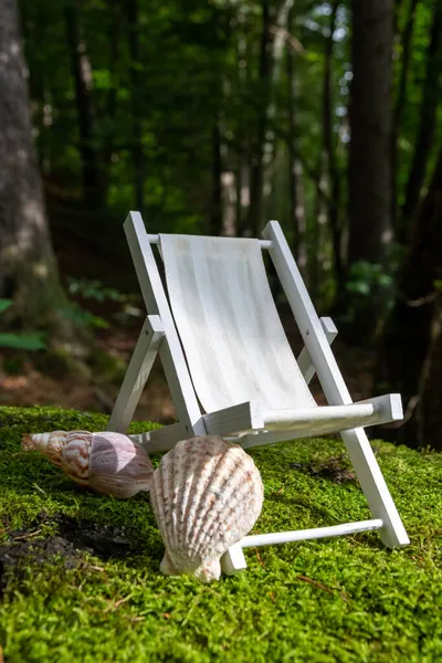 A vertical shot of a miniature garden lounge chair wit seashells