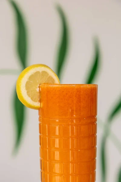 Ein Glas Karottensaft Mit Zitronenscheibe Vor Einem Hintergrund Mit Grünen — Stockfoto