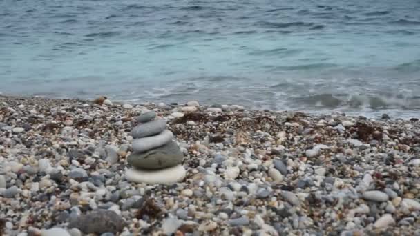 Szerokie ujęcie ludzi spacerujących po plaży z górami w oddali w ciągu dnia — Wideo stockowe