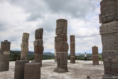 The Toltec warrior stone figures against a cloudy sky in Tula De Allende, Mexico clipart