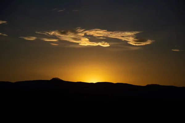 山のシルエットの向こうの夕日 — ストック写真
