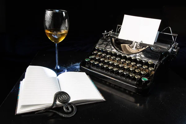 Μια Γραφομηχανή Χαρτί Ένα Σημειωματάριο Και Ένα Ποτήρι Κρασί — Φωτογραφία Αρχείου