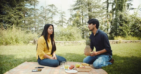 一对印度夫妇在绿树成荫的花园里野餐 — 图库照片
