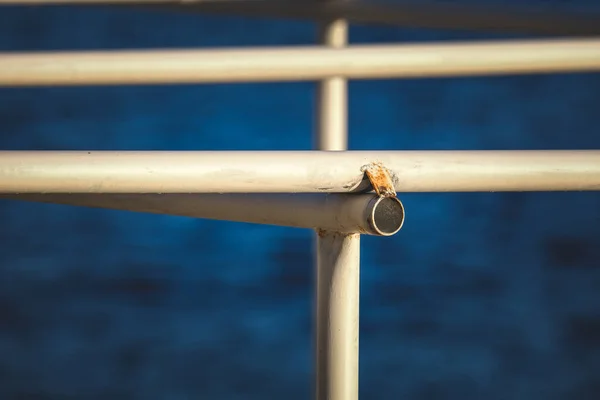 Ένα Κοντινό Πλάνο Ενός Λευκού Μεταλλικού Φράχτη Θάλασσα Στο Βάθος — Φωτογραφία Αρχείου