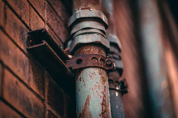 レンガ壁のブイに古いと素朴な金属パイプのクローズアップショット — ストック写真