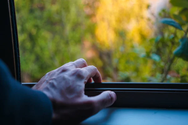 自然の景色と窓の上で老人の手のクローズアップショット — ストック写真