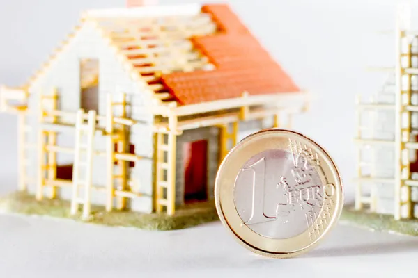 小房子背景上的一个欧元硬币 — 图库照片