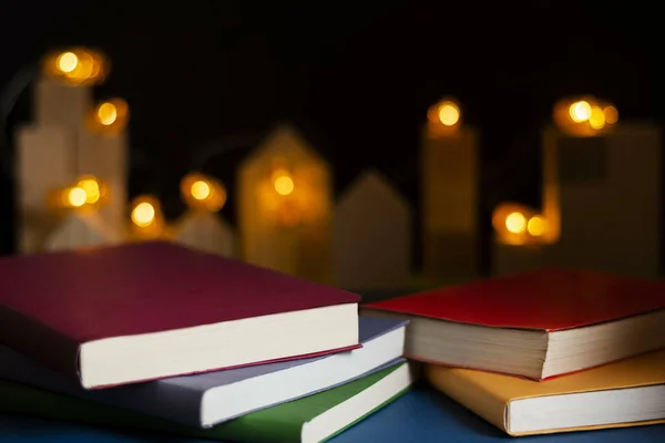 Een Close Shot Van Opgestapelde Boeken Tegen Wazig Aangestoken Kaarsen — Stockfoto