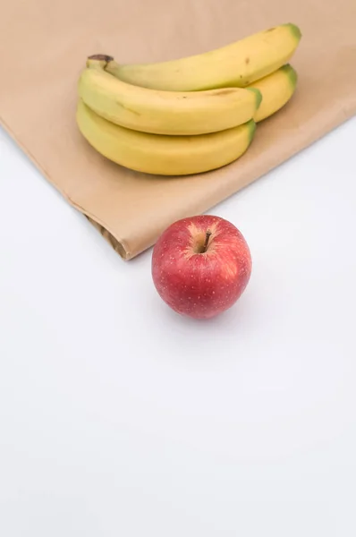 Dojrzałe Biologiczne Czerwone Jabłko Banany Białym Tle Papierowej Torbie Przestrzenią — Zdjęcie stockowe