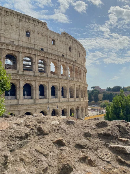 イタリアのローマに小さな雲と青い空の下でコロッセオの外観の垂直ショット — ストック写真