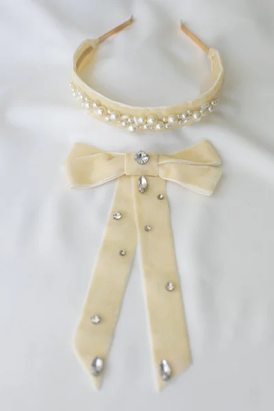 かわいい真珠と白い背景に蝶ネクタイを持つ空想のヘッドバンドの垂直ショット — ストック写真