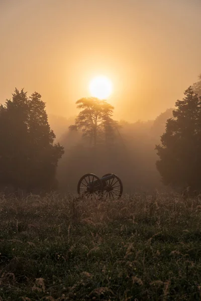 A historic battle gun in the misty Manassas National Battlefield Park during sunrise