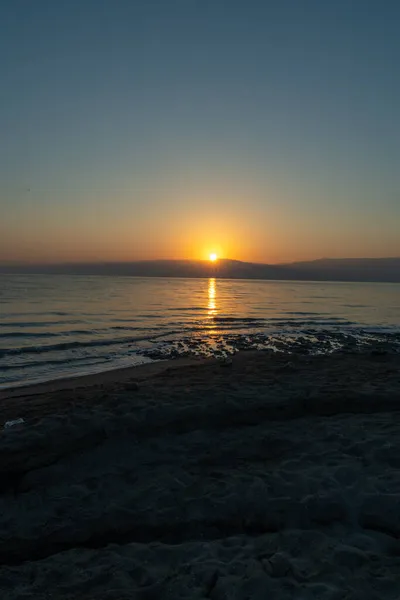 Вертикальный Снимок Пляжа Окруженного Морем Время Восхода Солнца Утром — стоковое фото