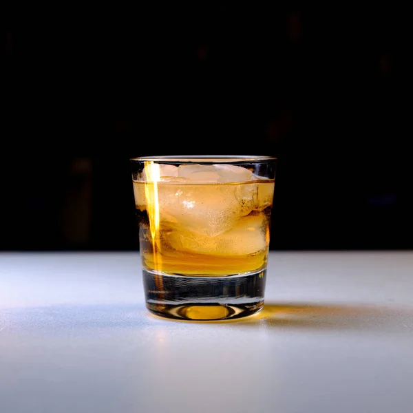 冷冰冰威士忌的特写镜头 放在桌子上 背景是黑色的 — 图库照片