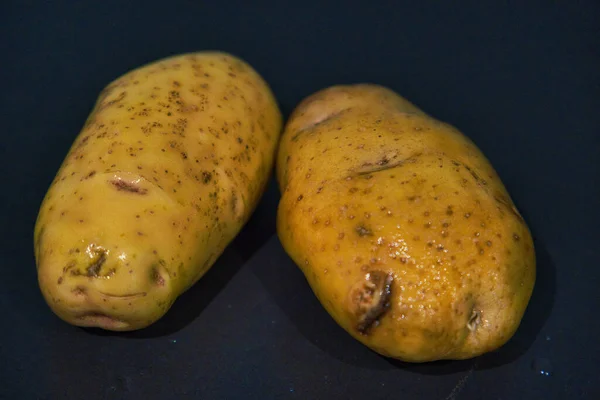 Batatas Cruas Não Cozidas Uma Superfície Preta — Fotografia de Stock