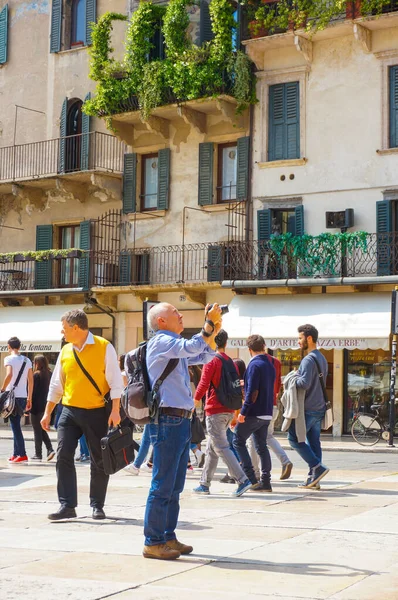 2016年4月29日 意大利维罗纳 一个在餐馆旁与许多人在广场上拍照的男人 — 图库照片