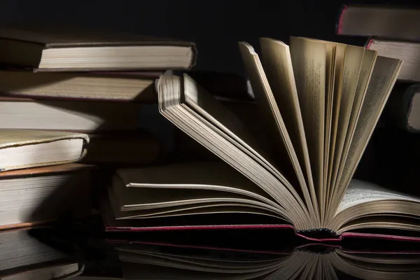 Ένα Κοντινό Πλάνο Σάρωσε Βιβλία Μια Λεία Επιφάνεια Απομονωμένη Σκοτεινό — Φωτογραφία Αρχείου