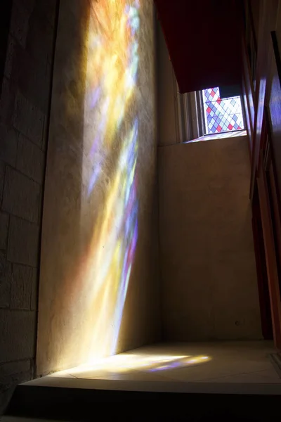 从教堂墙上的彩色玻璃上垂直拍出的彩色阴影 — 图库照片