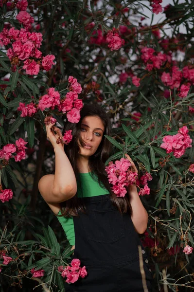 Atrakcyjna Hiszpanka Pozująca Przy Drzewie Różowymi Kwiatami — Zdjęcie stockowe