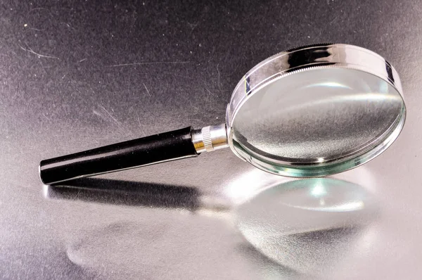Close Shot Handheld Magnifying Glass Metal Frame Reflected Silver Surface — Stock Photo, Image