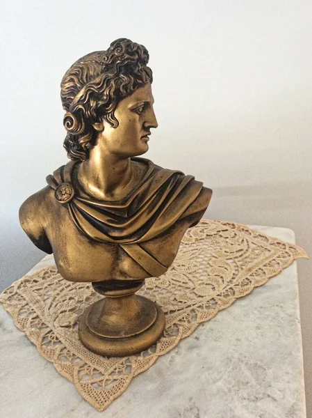 A bronze sculpture of Apollo on a table