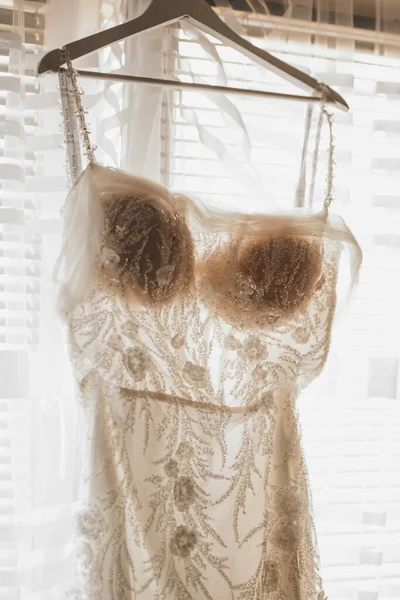 Tiro Vertical Vestido Noiva Pendurado Perto Uma Janela — Fotografia de Stock