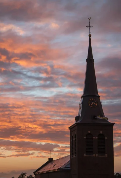 夕阳西下 一座古老而又长的尖塔映衬着灰色的橘红色天空 美丽的风景映衬着它 — 图库照片