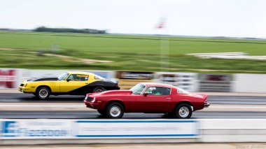 A side view of two sports cars during a drag racing in Kearney, NE clipart