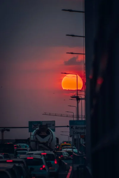 夕暮れ時の風光明媚な空の下で交通中の車と通りの垂直ショット — ストック写真