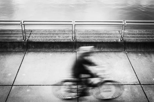 自転車に乗る男のぼやけたグレースケール — ストック写真