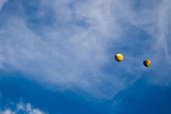 蓝色阴天背景上的黄色气球 — 图库照片