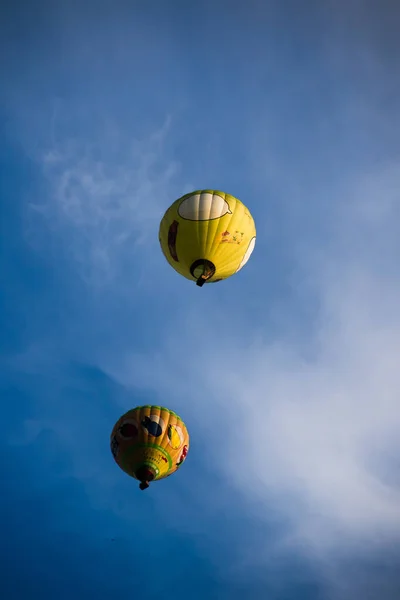 Pionowe Ujęcie Żółtych Balonów Powietrza Niebieskim Tle Zachmurzonego Nieba — Zdjęcie stockowe