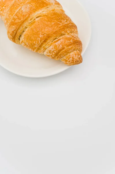 Záběr Čerstvého Máslového Croissantu Talíři Bílém Pozadí Textovým Prostorem — Stock fotografie