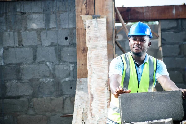 一名非洲建筑工人在建筑工地工作时穿着反光夹克 — 图库照片