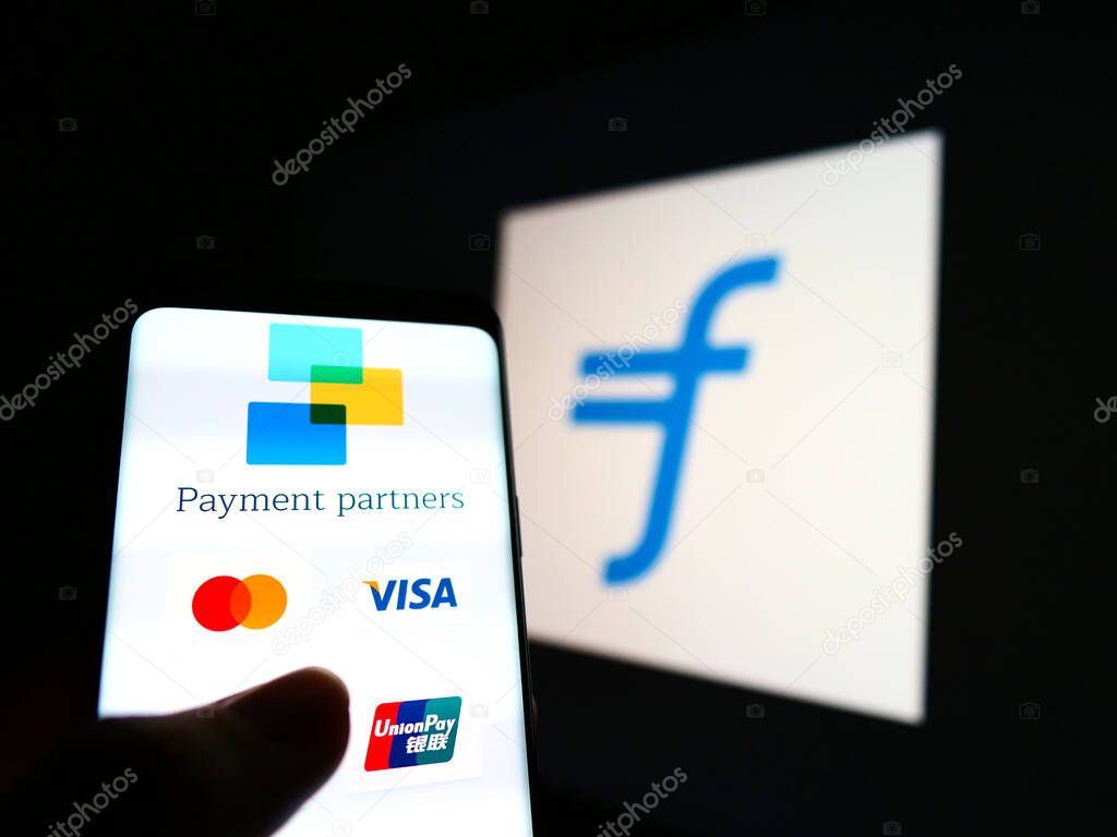 STUTTGART, GERMANY - Jan 23, 2021: Website of payment services provider Flywire with listed partners on phone screen in front of logo. Focus on center of smartphone screen.
