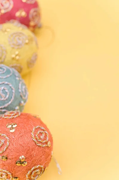 Veelkleurige Kerstballen Met Spint Voor Tekst Een Geel Oppervlak — Stockfoto