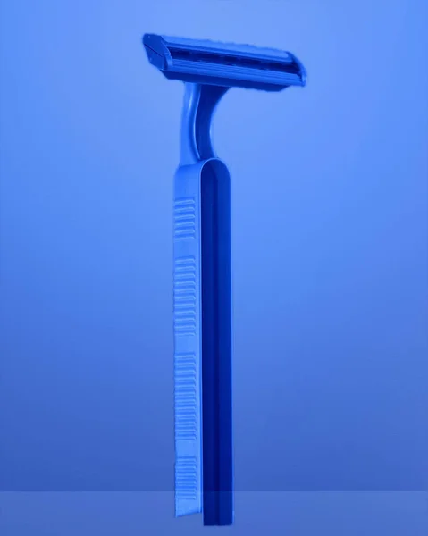 Eine Vertikale Nahaufnahme Eines Blauen Einweg Rasierers Auf Blauem Hintergrund — Stockfoto