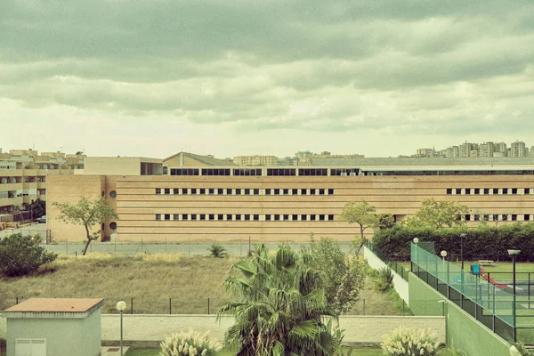 Ein Langes Gebäude Mit Einem Grünen Sportplatz Davor Einem Bewölkten — Stockfoto