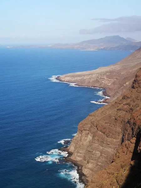 Eine Vertikale Aufnahme Eines Blauen Ozeans Umgeben Von Felsigen Hügeln — Stockfoto