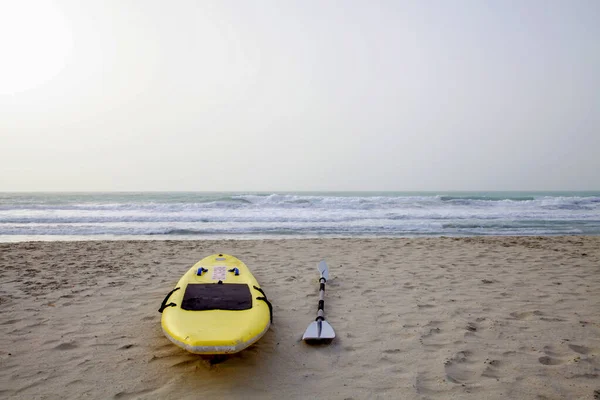 迪拜海滩上有桨的黄色冲浪板 — 图库照片