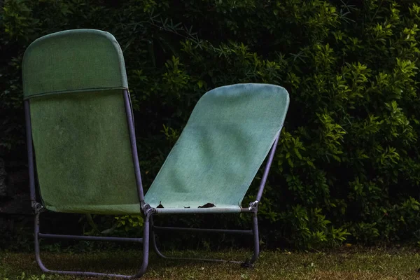 花园里的一把旧的 肮脏的绿色躺椅 — 图库照片