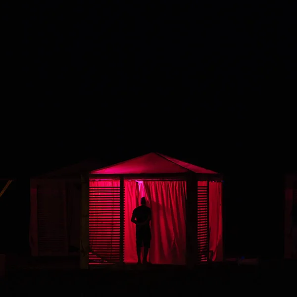 Sylwetka Owieka Zaglądaj Cego Przez Zasłony Czerwonego Podświetlanego Namiotu Pla — Zdjęcie stockowe