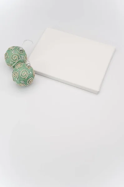 优雅的绿色银色圣诞装饰品和用蓝宝石在白色表面作画的画布 — 图库照片